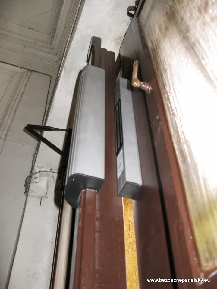 Detail hornej hliníkovej lišty s EMG zámkom pri pootvorených dverách